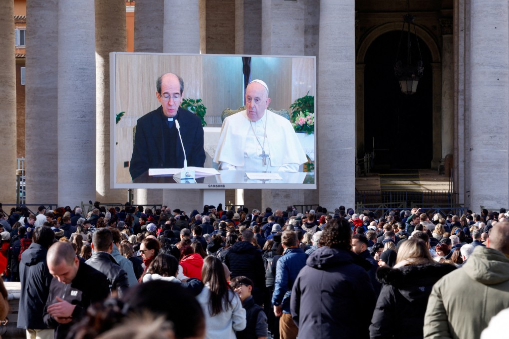 Monsignor Paolo Braida reads next to Pope Francis as they appear on a screen in St Peter’s Square, during the Angelus prayer led by Pope Francis from Santa Marta chapel at the Vatican. Photo: Reuters