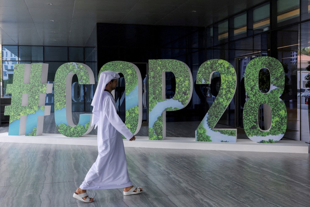 A man walks past a “#COP28” sign in Abu Dhabi. Over 60 countries have already agreed to back the deal, spearheaded by the European Union, United States and United Arab Emirates, to triple renewable energy this decade ahead of the summit. Photo: Reuters