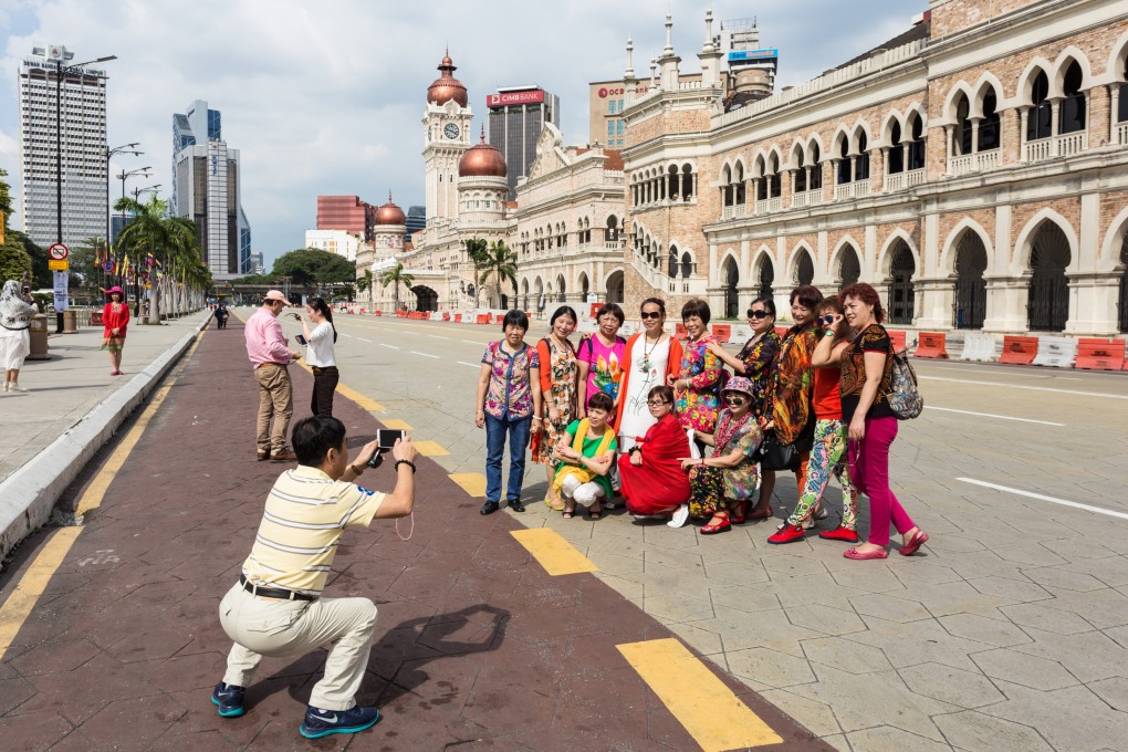 A group of Chinese tourists poses for a photo in front of the Sultan Abdul Samad building near Independence Square in Malaysia’s Kuala Lumpur. Photo: Shutterstock