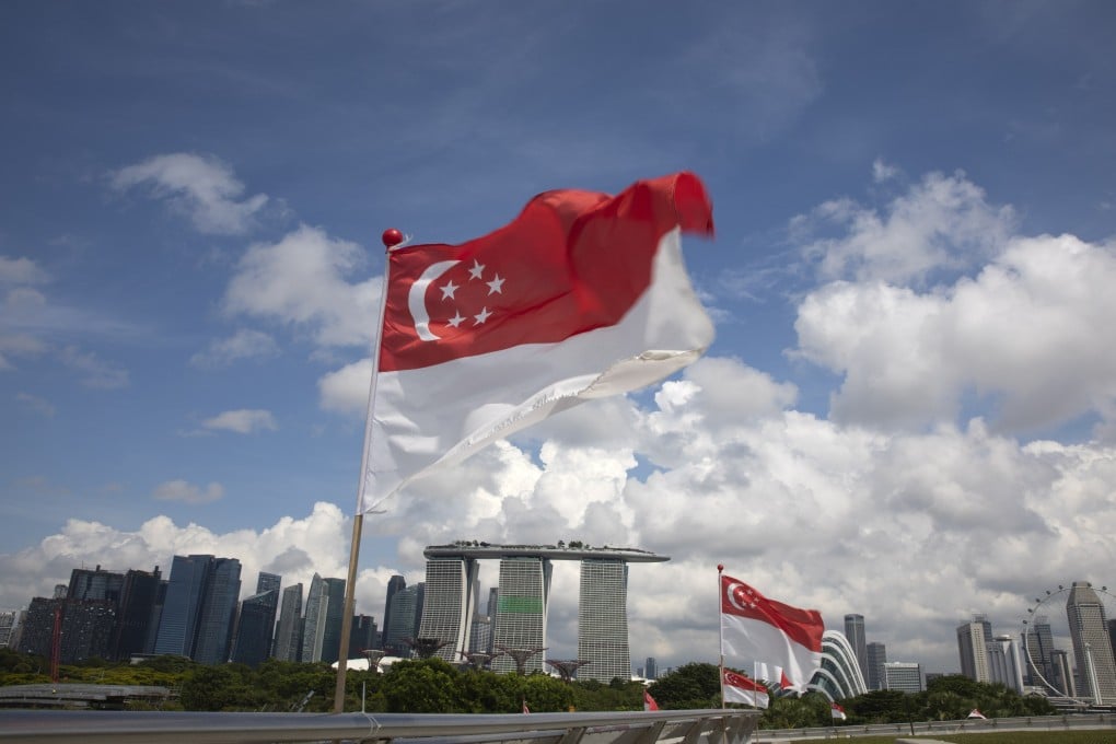 Singapore national flags flutter over a view of the city skyline. This was the first prosecution for an offence under a clause in the Penal Code that criminalises the exploitative sexual penetration of a minor between 16 and 18 years old. Photo: EPA-EFE