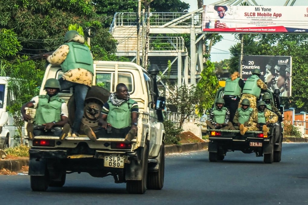 Soldiers riding in the back of army pickups in Freetown, Sierra Leone, on Monday. Photo: EPA-EFE