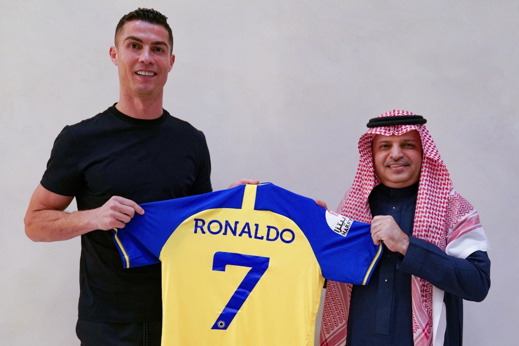 Portuguese football player Cristiano Ronaldo is presented with Al-Nassr’s number seven jersey by club president Musalli Al-Muammar in Madrid on December 30, 2022 upon signing for the Saudi Arabian club. Photo: AFP