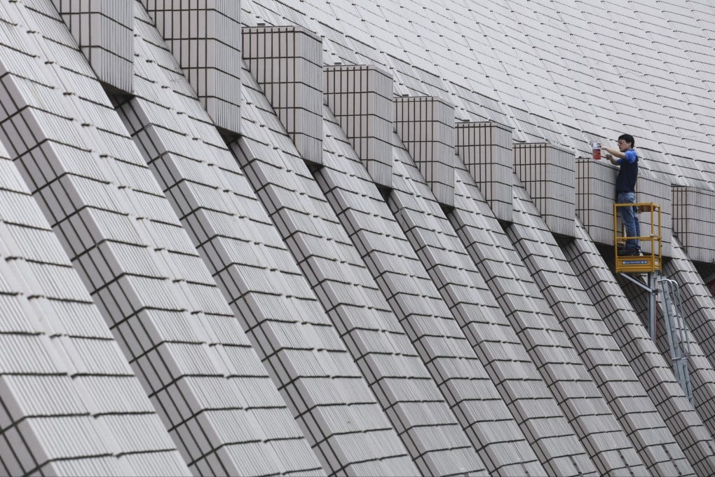 A worker cleans the dust-pink glazed ceramic tiles on the Hong Kong Cultural Centre in Tsim Sha Tsui. Photo: Felix Wong