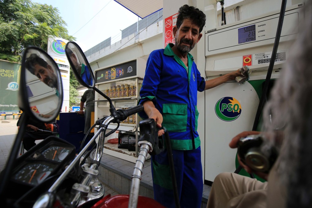 A gas station attendant fills the tank of a motorcycle in Peshawar, Pakistan. Photo: EPA-EFE