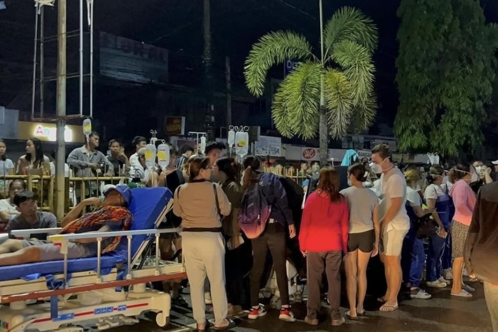 Patients and locals rest outside a hospital in Butuan city in the Philippines early Sunday after tremors struck off the coast of Mindanao island, causing a tsunami alert. Photo: EPA
