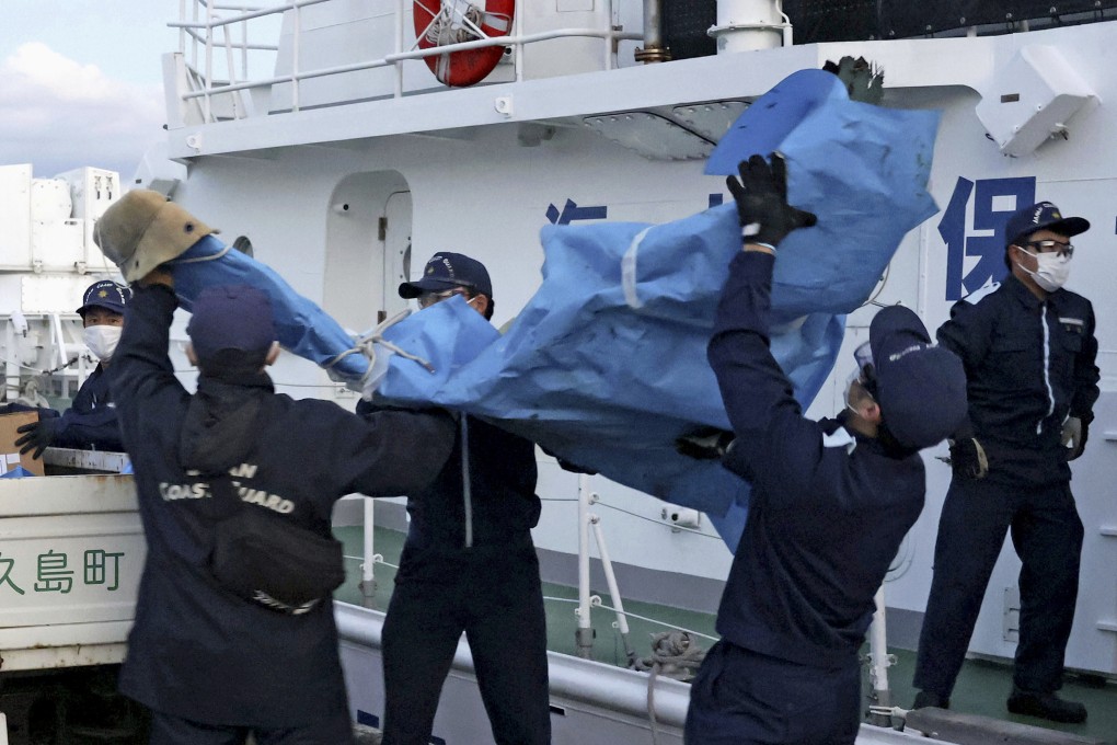 Members of the Japanese Coast Guard carry debris believed to be from the crashed US military Osprey aircraft on December 4. Photo: Kyodo News via AP