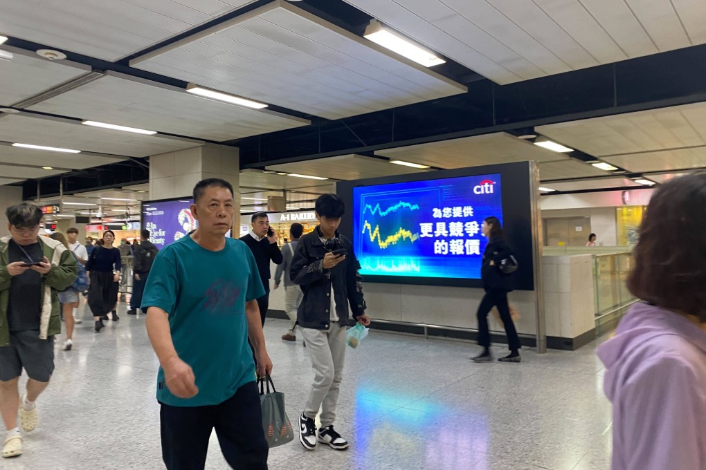 People walking past a stock screen inside an underground mall in Hong Kong on December 5, 2023. Photo: Li Jaixing
