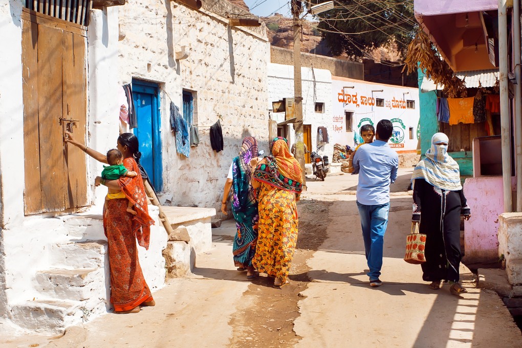 People walk along a narrow street in a small town in Karnataka state. Photo: Shutterstock