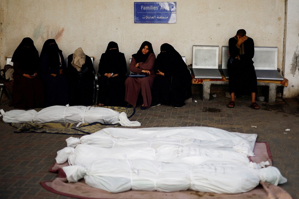 People sit next to the bodies of Palestinians killed in Israeli strikes in Rafah, in the southern Gaza Strip. Photo: Reuters