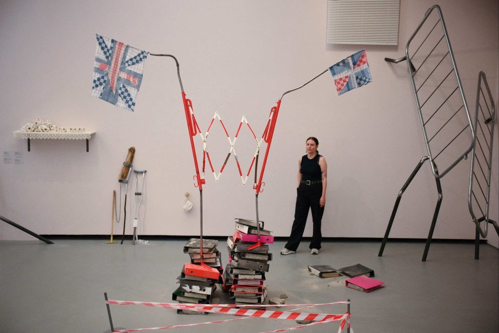 A gallery assistant poses next to installations by artist Jesse Darling titled Gorgon (Britannia) and Come on England (Up The) at the Towner Eastbourne gallery in England in September. Photo: AFP