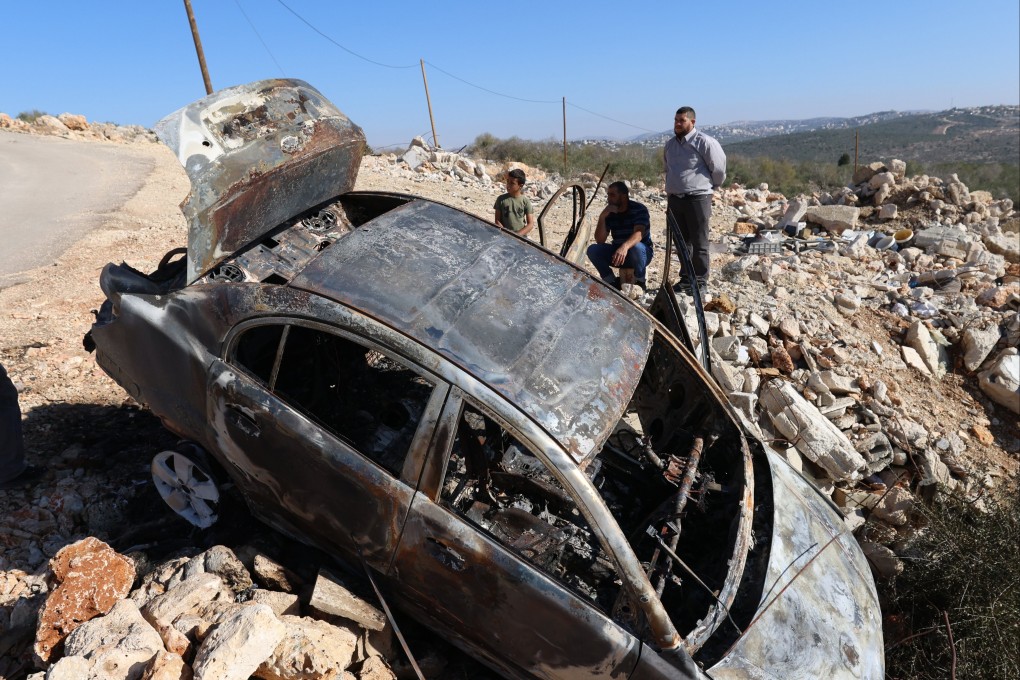 Palestinians inspect a burnt out car at Qarawa village on Sunday, after Israeli settlers attacked two Palestinian villages in the West Bank. Photo: EPA-EFE