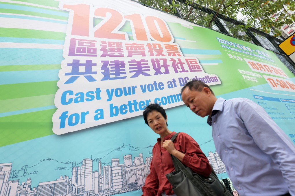 People walk past the large-scale promotional poster for the 2023 District Council Election in Mong Kok. Photo: Jelly Tse