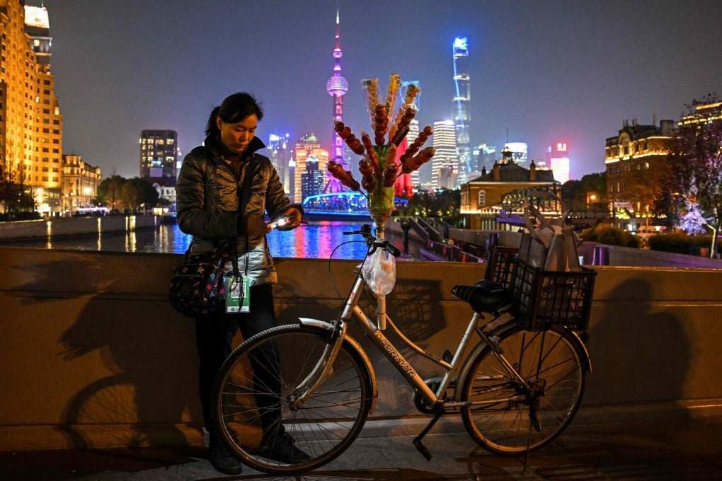 A vendor stands over the Zhapu Road Bridge in the Huangpu district in Shanghai on December 6. China’s drift from the global economic spotlight could give policymakers room to make needed adjustments but also brings risks of its own. Photo: AFP