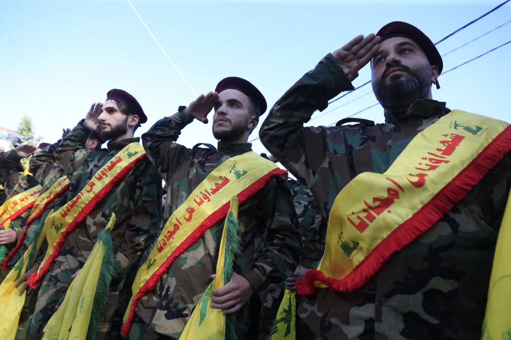 Members of the Hezbollah movement salute during the funeral of a fighter killed during cross-border clashes with Israel. Photo: AFP
