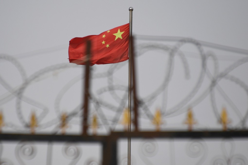The Chinese flag is seen behind razor wire at a housing compound in Yangisar in China’s Xinjiang Uygur autonomous region in June 2019. Photo: AFP