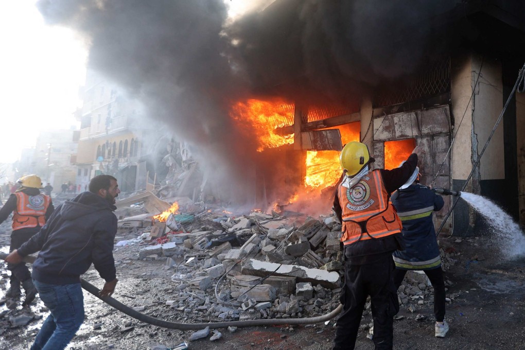 Firefights battle flames in a building hit by an Israeli strike in Khan Yunis in the southern Gaza Strip on Saturday. Photo: AFP