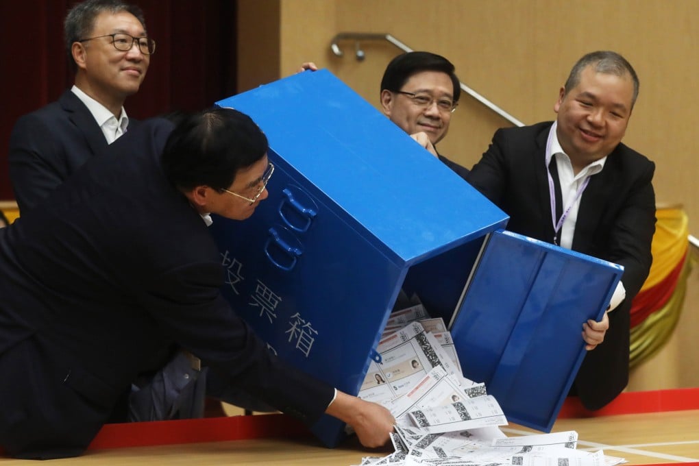 Chief Executive John Lee (second right) watches as a ballot box is opened at a district council polling station at Queen’s College, Causeway Bay. Photo: Sun Yeung