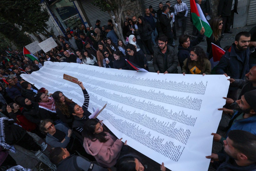 Palestinians carry a list of Gaza victims during a rally in Ramallah city, in the occupied West Bank on Monday. Photo: AFP