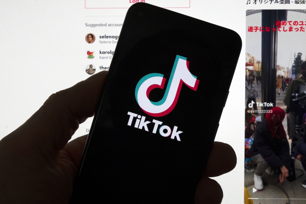 The TikTok logo seen on a mobile phone in front of a computer screen which displays the TikTok home screen on March 18, 2023. Photo: AP