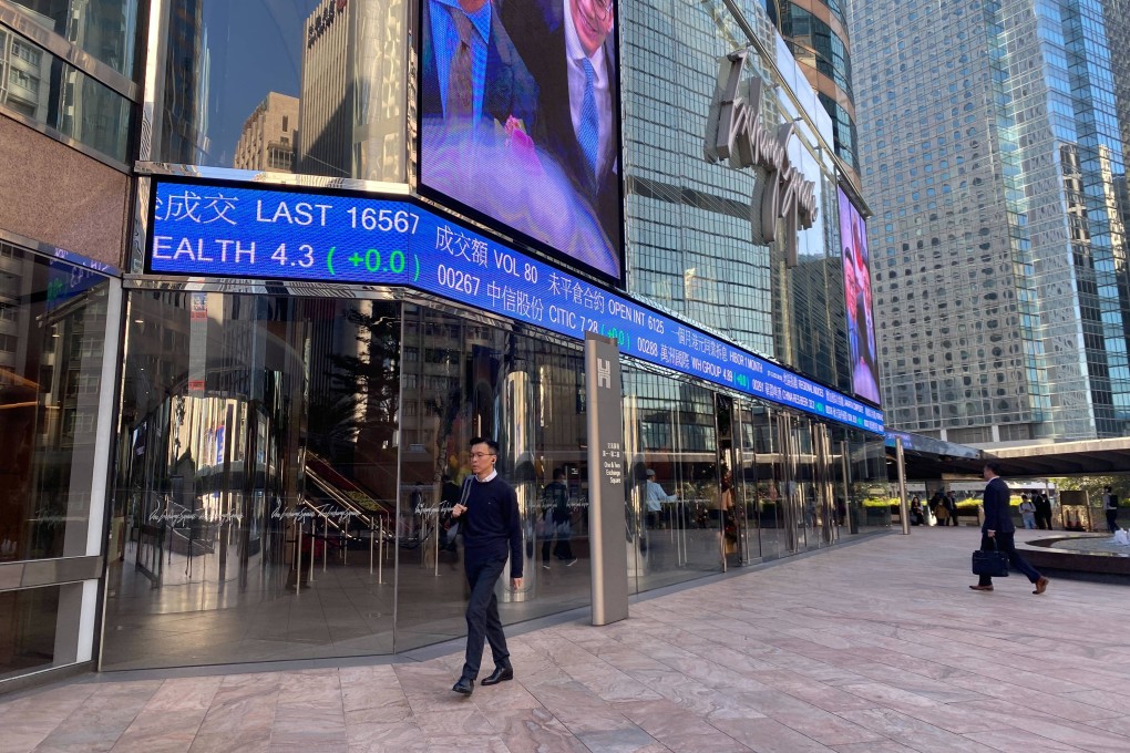 People walking outside the Exchange Square in Central, Hong Kong with tickers showing stock prices on December 7, 2023. Photo: Li Jiaxing