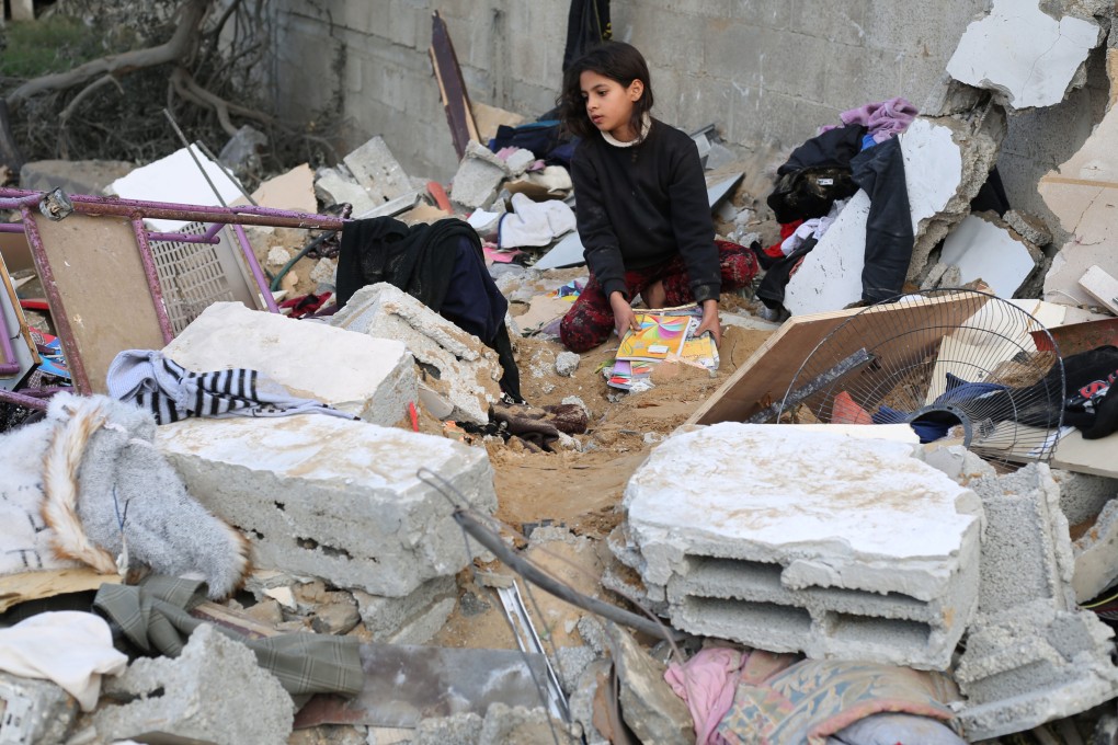 A girl collects items among the rubble of a building after an Israeli airstrike in the southern Gaza Strip city of Rafah on December 12.  Photo: Xinhua