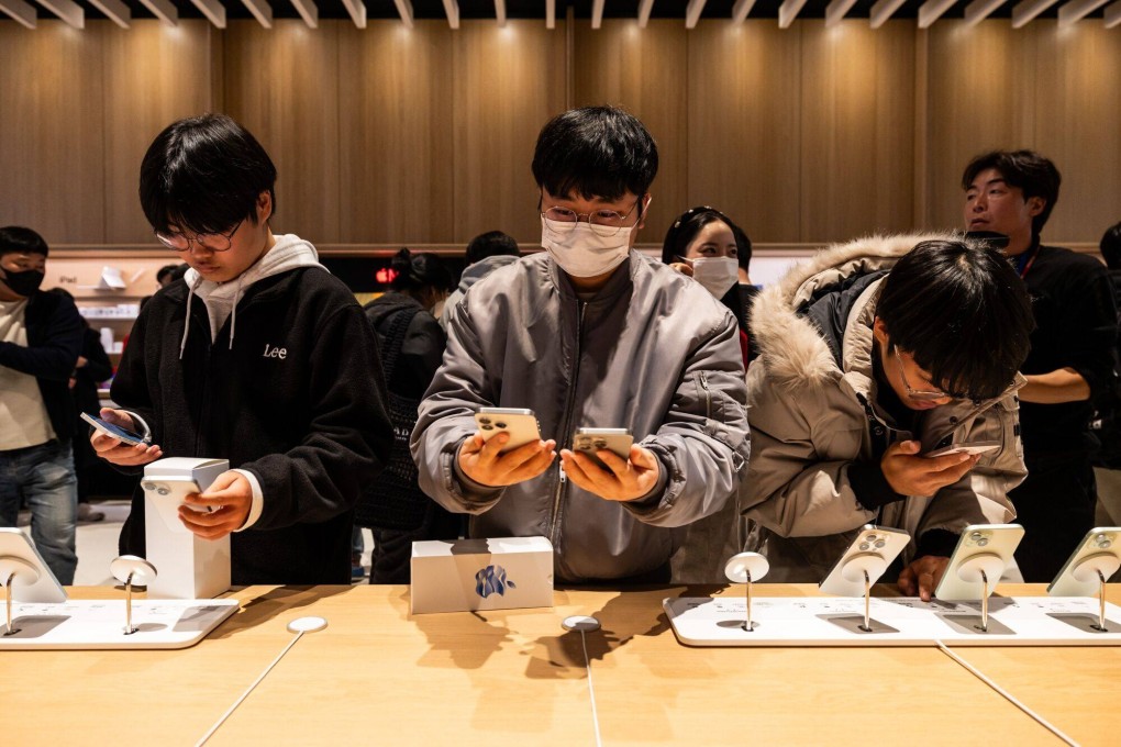 Customers look at iPhone models at an Apple store in Hanam, South Korea. Photo: Bloomberg