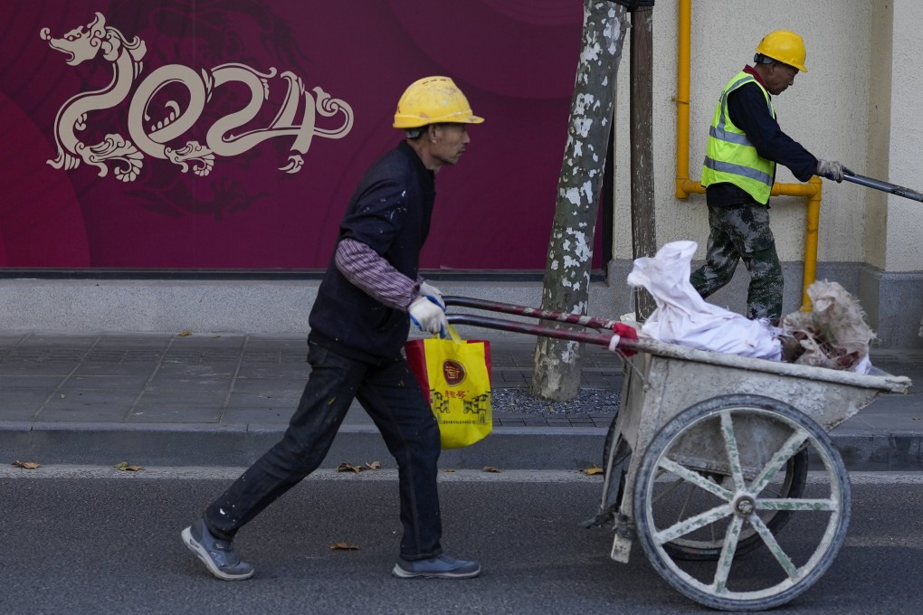 Workers push trolleys past an under-construction shop featuring a dragon in the shape of 2024, the Year of the Dragon in the Chinese calendar, in Shanghai on November 25. Photo: AP