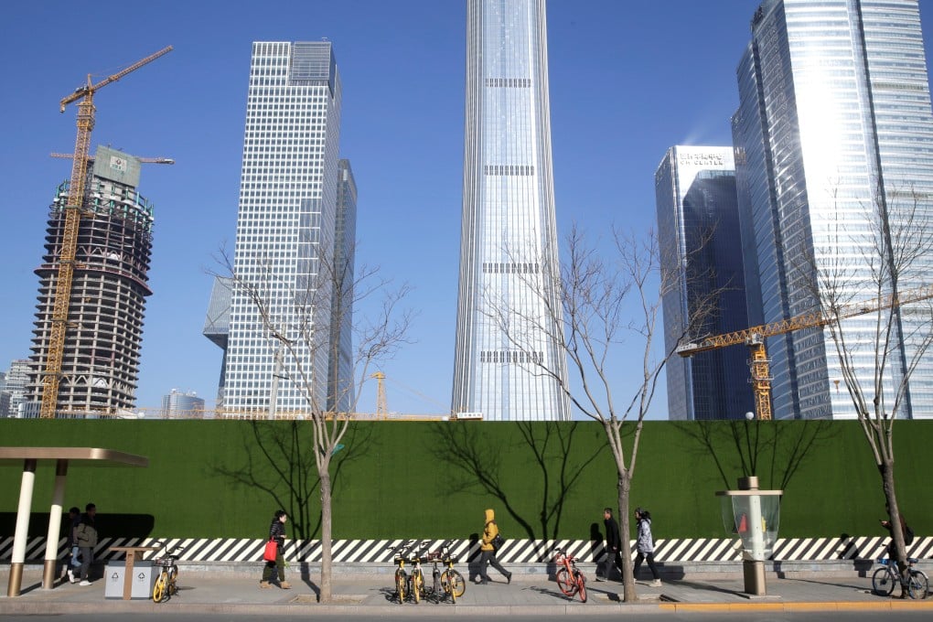 People pass a construction site in Beijing. The Politburo’s embrace of more stable policies in 2024 could stabilise the expectations of people and businesses. Photo: Reuters