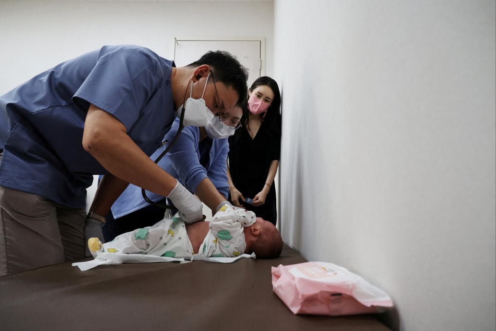 A pediatrician treats a baby as his mother looks on at a clinic in Seoul on June 14. Photo: Reuters