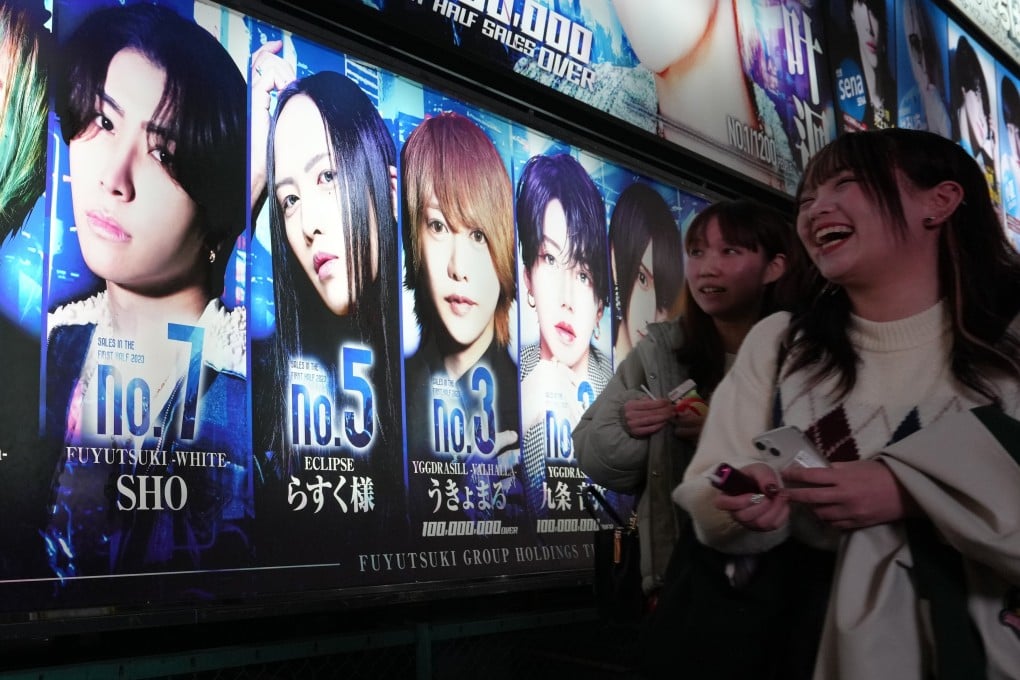 Women walk past a billboard of a host club at Kabukicho in Tokyo’s Shinjuku district on December 6. Photo: EPA-EFE