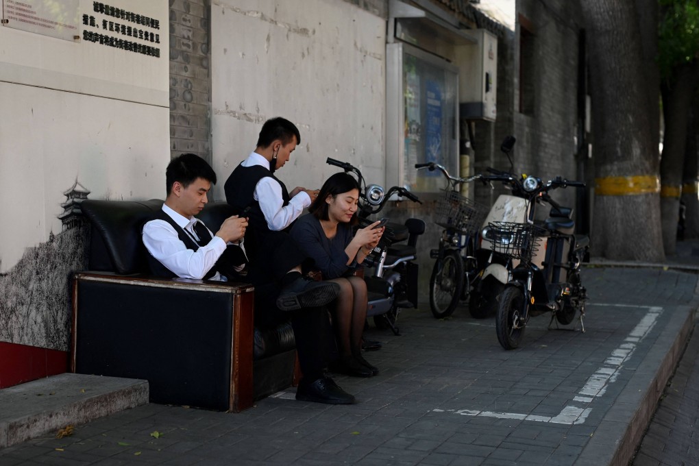 A group of people use their mobile phones to play online video games in Beijing, September 21, 2022. Photo: AFP