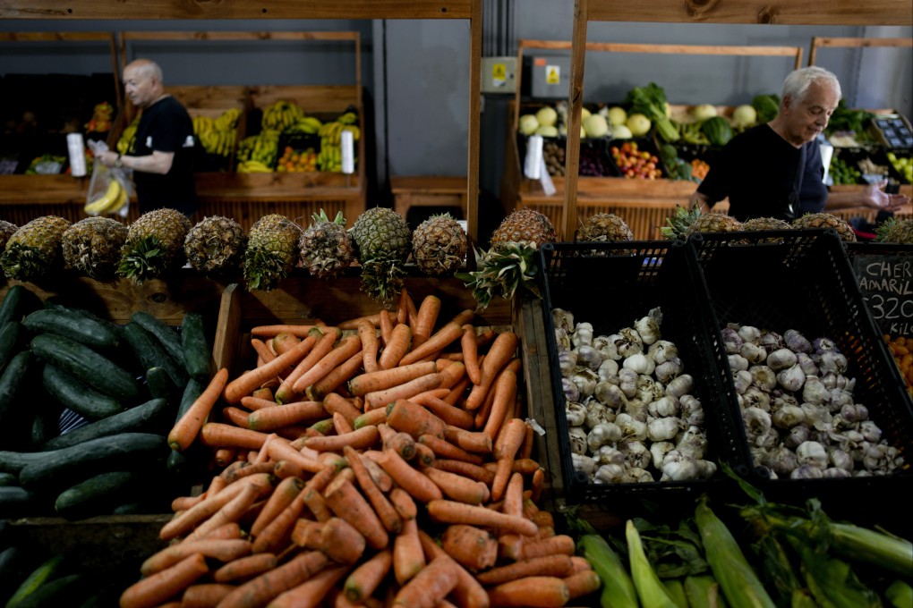 Shoppers buy vegetables in Buenos Aires, Argentina, on December 11. The persistence of debt distress and high interest rates have left consumers and many developing countries in potential financial peril at the cusp of a global downturn. Photo: AP
