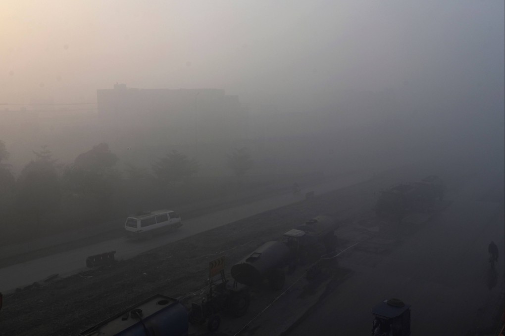 Commuters making their way along a street amid heavy smog in Lahore this week. Photo: AFP