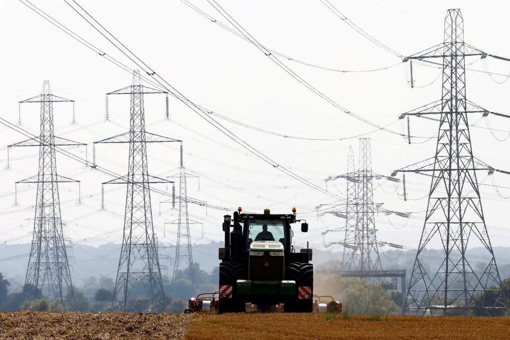 A farmer works in a field surrounded by electricity pylons in Ratcliffe-on-Soar, central England. Photo: Reuters