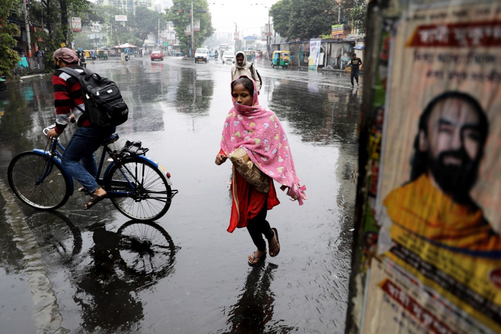 A girl walks during a rain shower in Kolkata. Women in India face violence and pressure from their husbands and in-laws if they do not bear a son. Photo: EPA-EFE