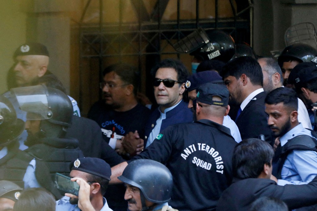 Security officers escort Pakistan’s former prime minister Imran Khan, as he appeared in Islamabad High Court on May 12. Khan – currently serving a three-year sentence in jail in a corruption case – will not be presently freed, as he still faces two other corruption cases. Photo: Reuters