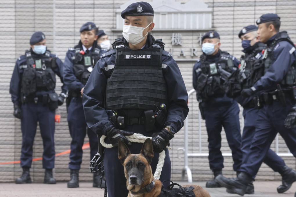 An officer and a police dog outside the court building. The force was out in numbers again on the third day of the trial. Photo: Jonathan Wong