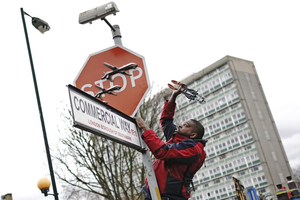 A man removes a piece of art by Banksy from an intersection in London on Friday. Photo: PA via AP
