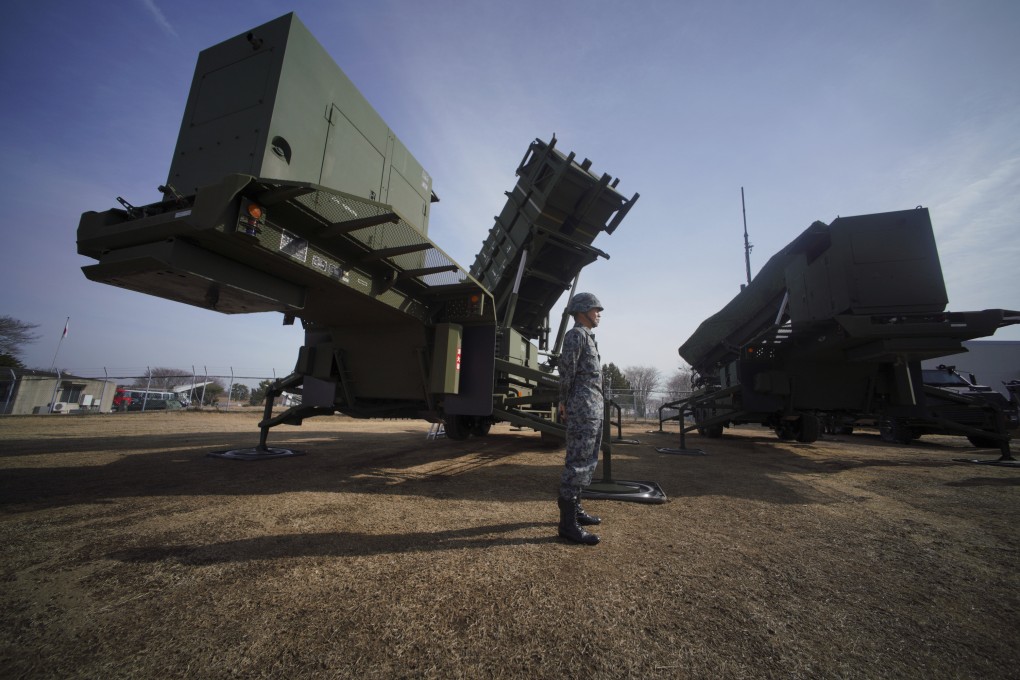 A Japanese soldier stands guard next to a surface-to-air Patriot missile interceptor launcher vehicle in Funabashi, east of Tokyo. File photo: AP