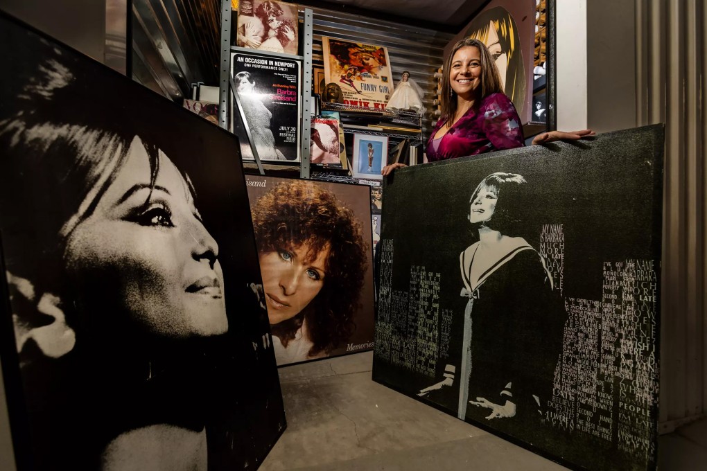 Mara Papalas stands amid Barbra Streisand memorabilia that makes up part of her late father’s vast collection, which she is hoping someone will buy. She has no personal interest in the items, and keeping them in storage costs money. Photo: Los Angeles Times/TNS