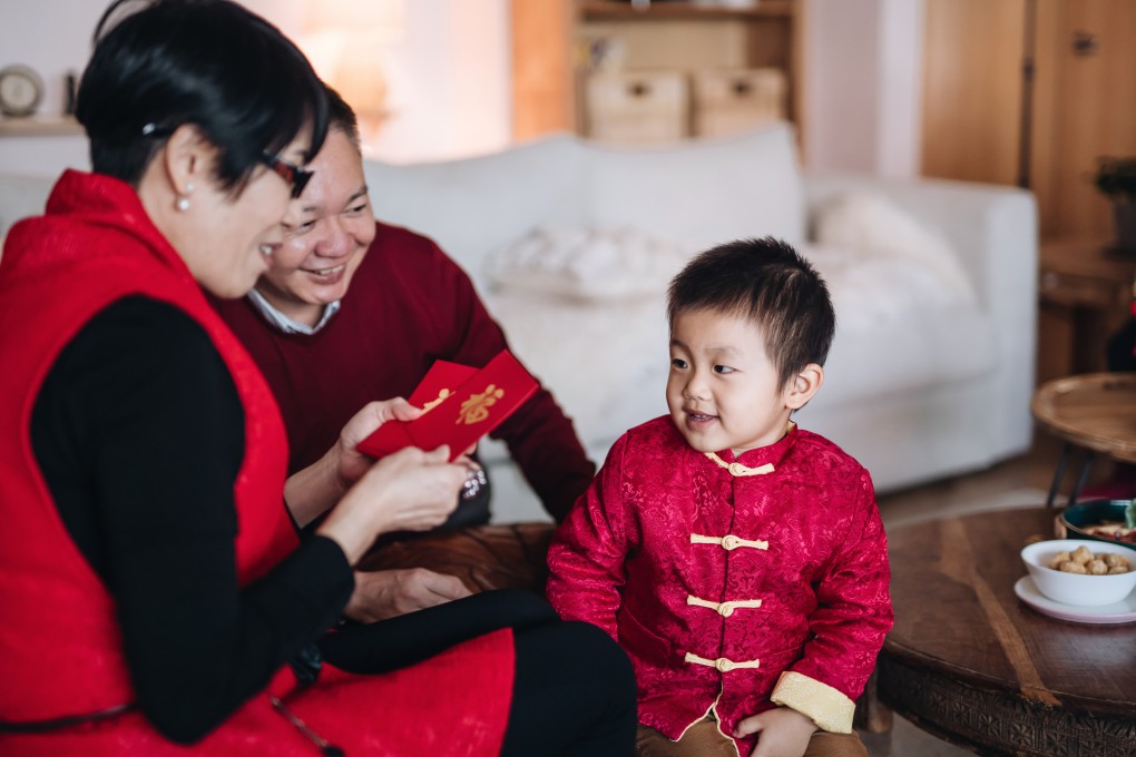 A child dressed in traditional red Chinese costume receives a lucky red envelope from his grandparents for Chinese New Year. China is far from being the only country in Asia where Lunar New Year festivities are held. Photo: Getty Images