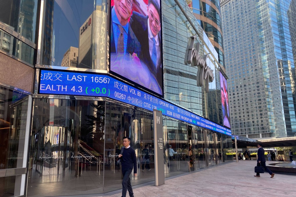 People walking outside the Exchange Square in Central, Hong Kong with tickers showing stock prices on December 7, 2023. Photo: Li Jiaxing