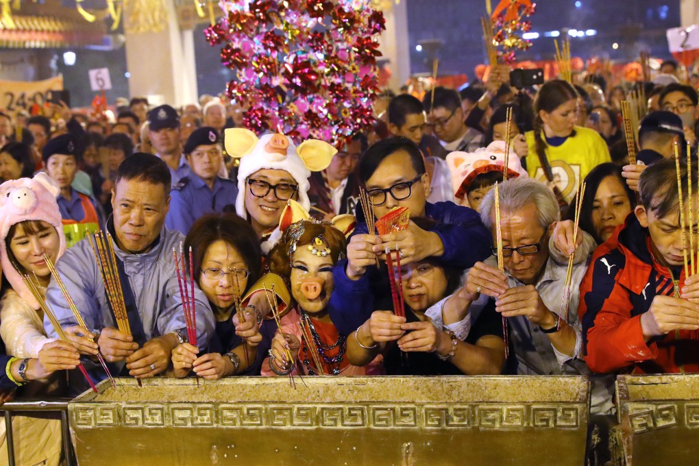 Worshippers, including a woman dressed in a pig costume, offer incense at Wong Tai Sin Temple in Hong Kong on Lunar New Year’s Eve in 2019. Festivities for Chinese New Year run to 16 days, with different traditions attached to each day. Photo: Edmond So