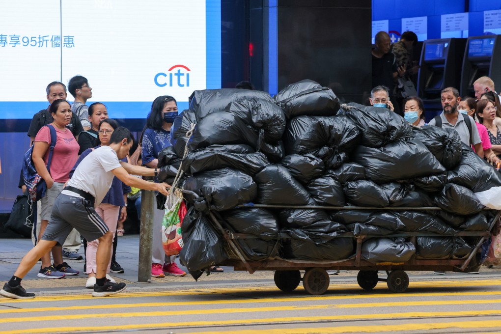 A worker hauls a cart with bags of rubbish in Central. Under a new waste-charging scheme set to  take effect on April 1, residents will be required to buy government-approved plastic bags. Photo: Jelly Tse