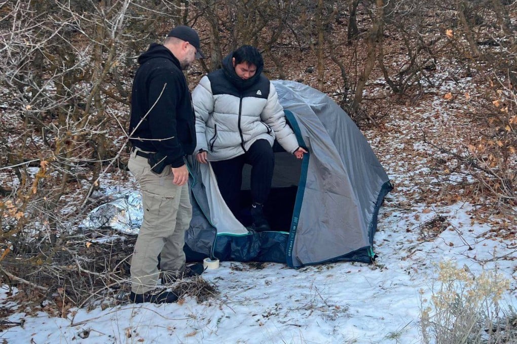 A police officer with Kai Zhuang at the site where he was found. Photo: Riverdale Police Department via AFP