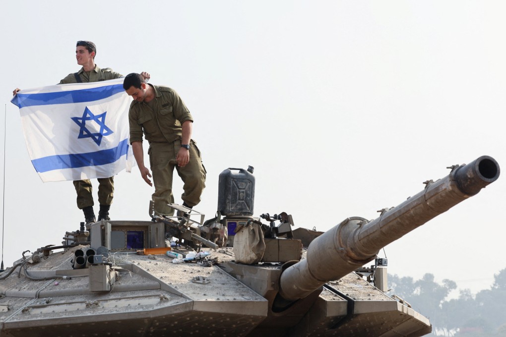 An Israeli soldier holds an Israeli flag on a tank, amid the ongoing conflict between Israel and the Palestinian Islamist group Hamas. Photo: Reuters