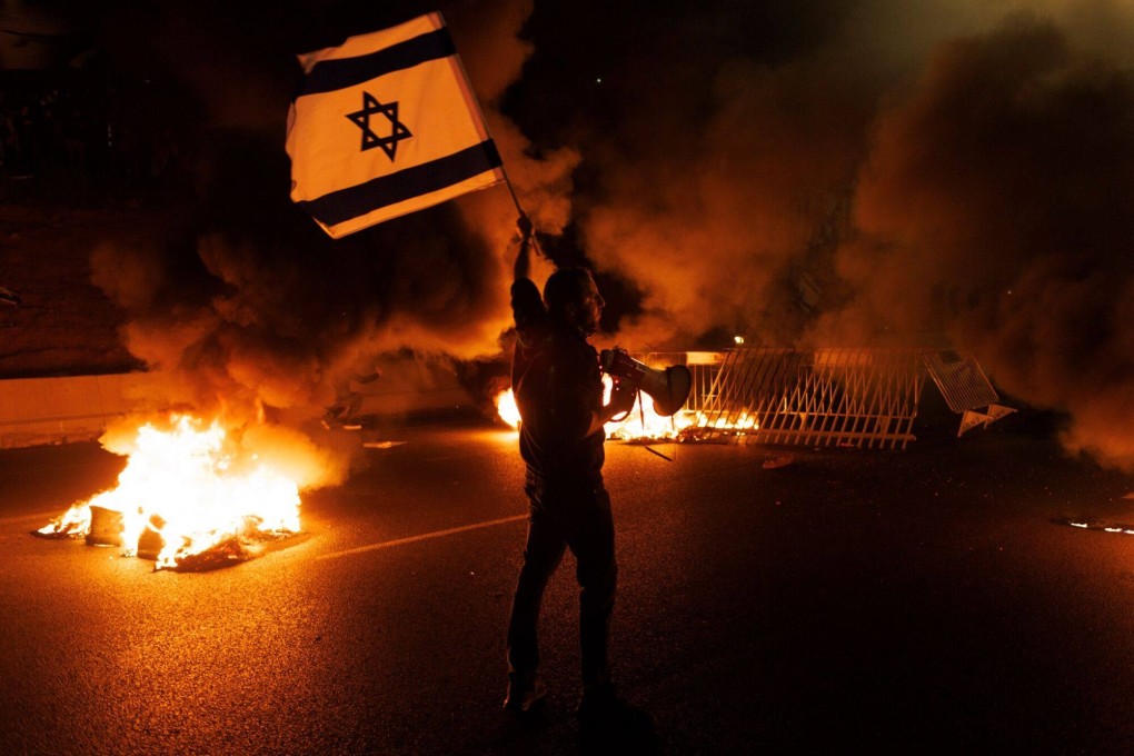 A protester waves an Israeli flag during a demonstration against Prime Minister Benjamin Netanyahu’s coalition government and proposed judicial reforms in Tel Aviv, Israel in March. Photo: Bloomberg