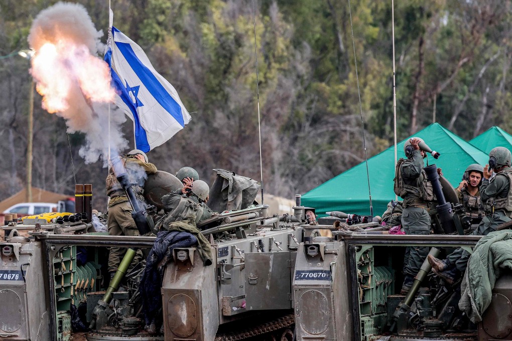 Israeli soldiers cover their ears as they a fire mortar round from an armoured vehicle at a position along the border in southern Israel on Wednesday. Photo: AFP