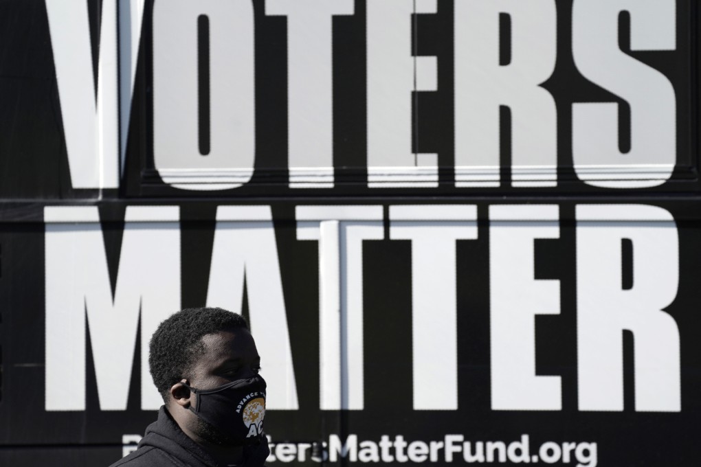 A man wearing a mask gathers with a group in support of Black Voters Matter in Graham, North Carolina, on November 3, 2020. This year’s US elections are among many across the world that could have wide-ranging impact on global markets. Photo: AP