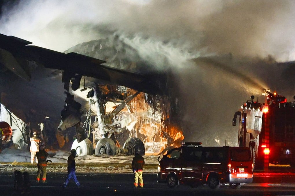Firefighters battle the blaze that broke out on the Japan Airlines plane after it had collided with a coastguard aircraft on a runway at Haneda airport in Tokyo on Tuesday evening. Photo: Kyodo